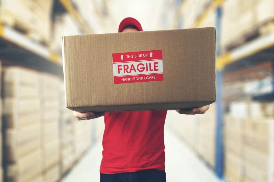 Man holding a labeled box before long-distance moving 