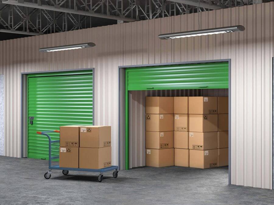 A view of a storage unit filled with boxes and a trolley with more boxes coming