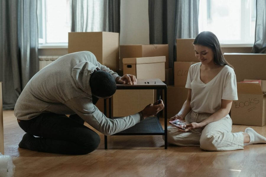 A man and woman sitting on the floor in their home