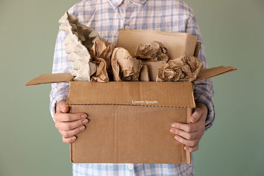 A person holding a box full of crumpled paper
