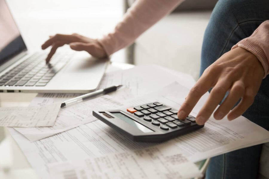 a woman is using calculator to count her costs for a long-distance moving