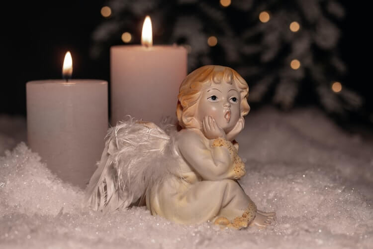 An angel figurine and candles in the background