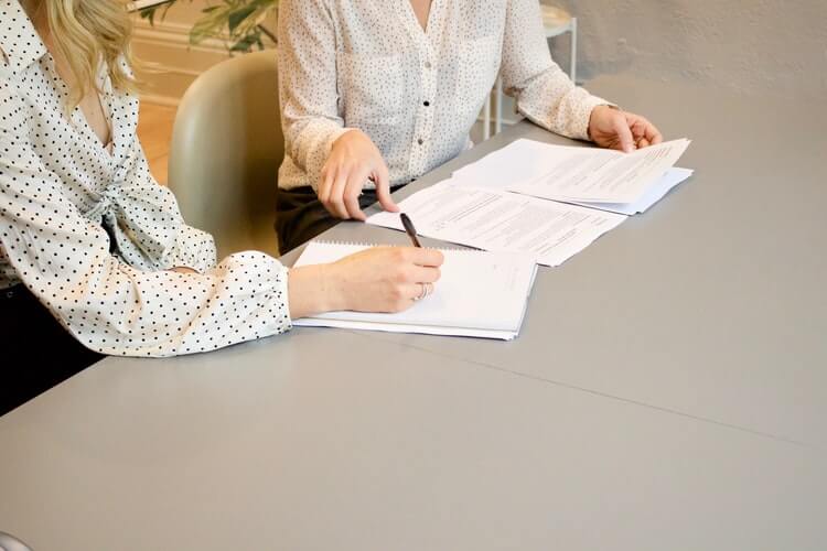 Woman signing a paper during an interview
