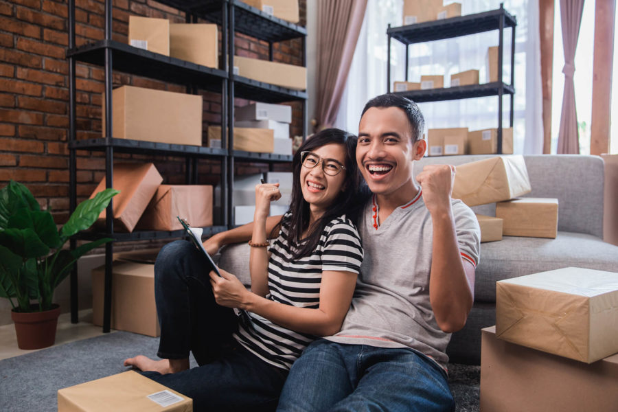 A couple smiling, surrounded by boxes