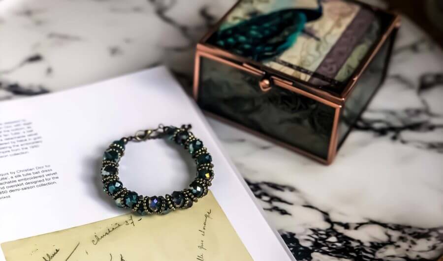 Jewelry box made of glass on a marble background with a bracelet in focus