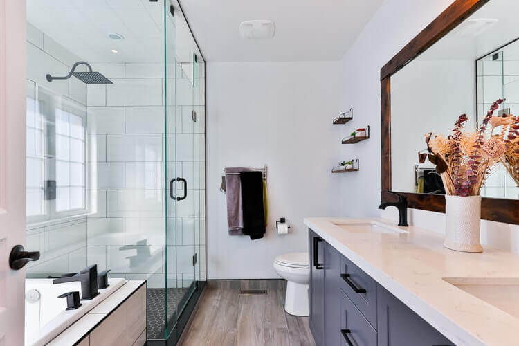 A ceramic sink and a glass shower doors