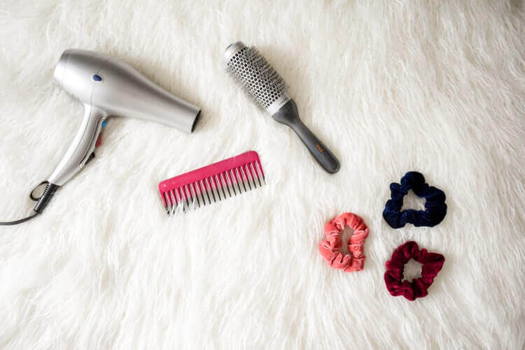 A comb, hair dryer, hair straightener and some scrunchies