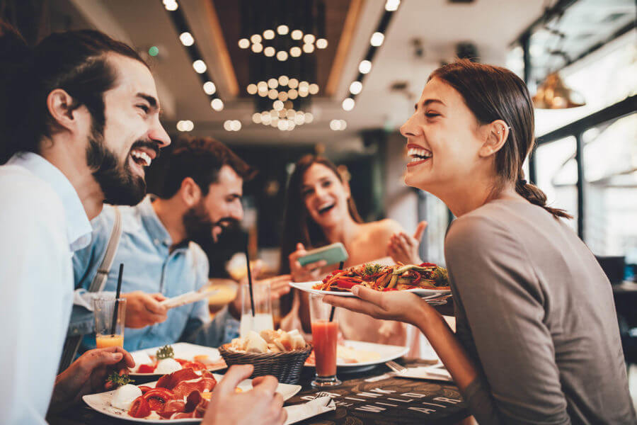 Smiling people in a restaurant after long-distance moving 