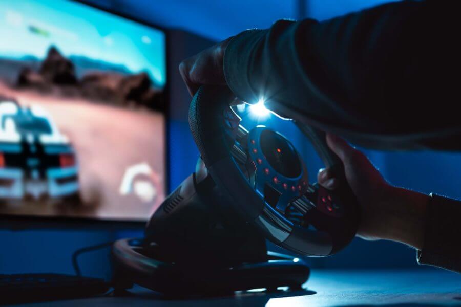 A person playing video games on a driving wheel