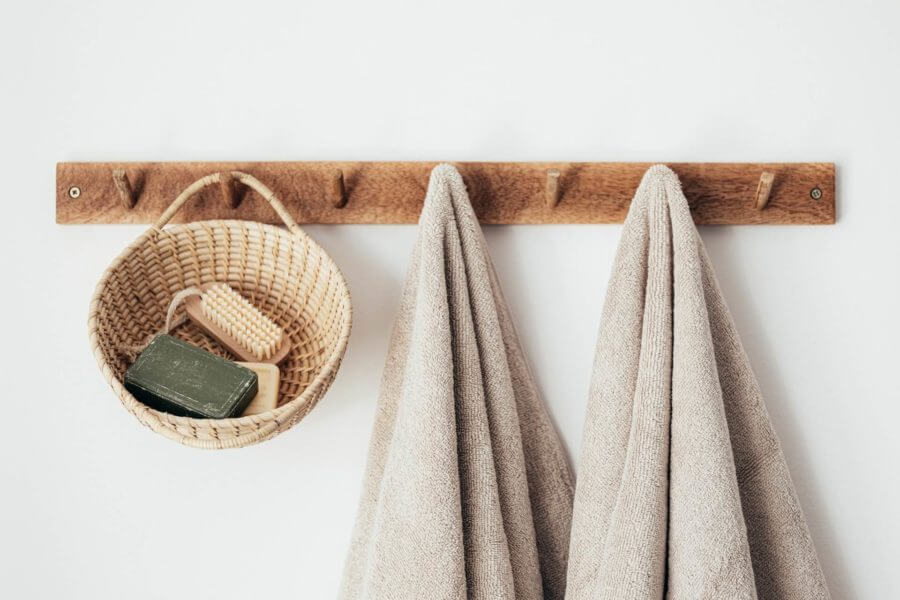 A wooden hook with towels and a basket