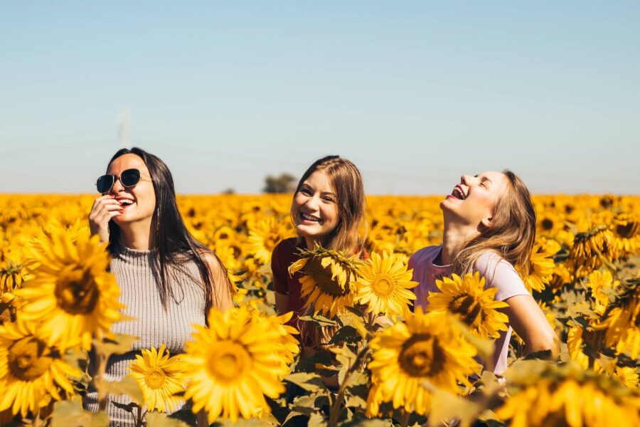 Happy friends in the field of sunflowers