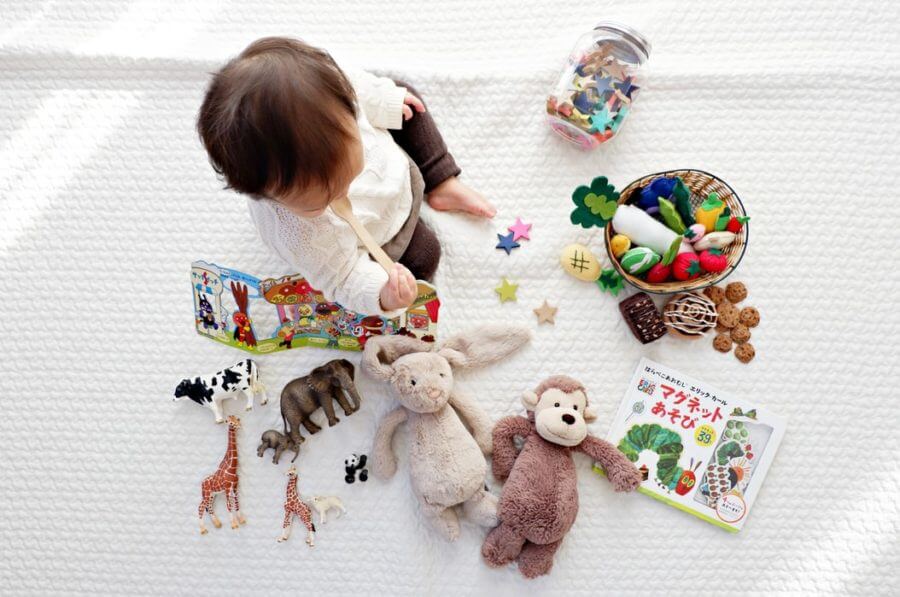 child surrounded by toys