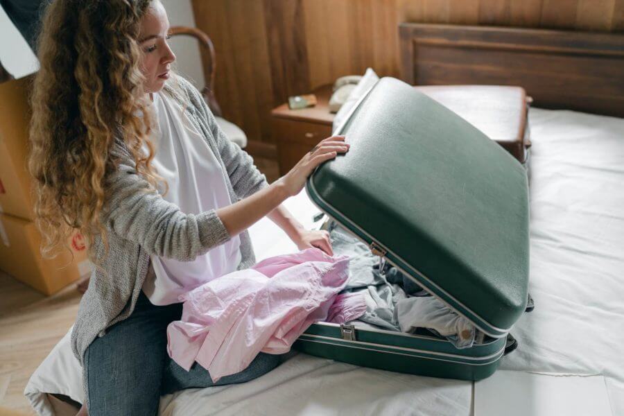 woman packing a suitcase in her bedroom