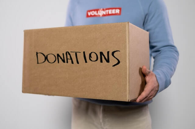 Man holding a box for donation before long-distance movin