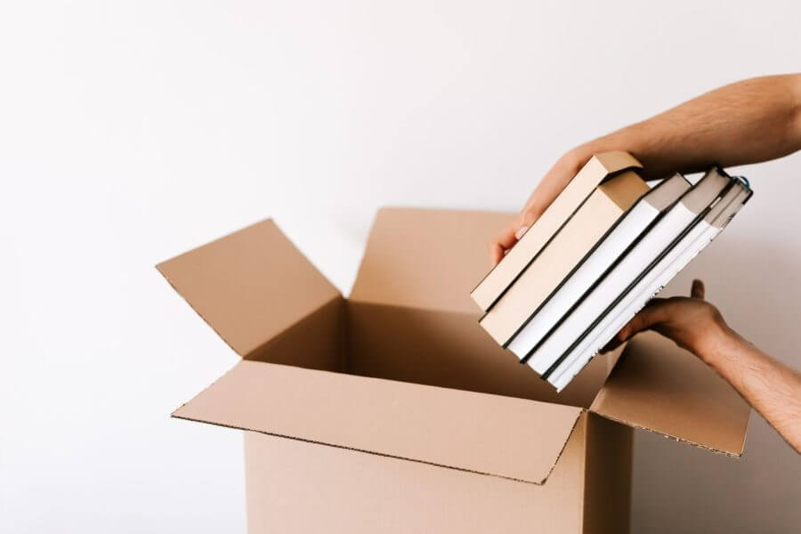A person packing books for moving across the country