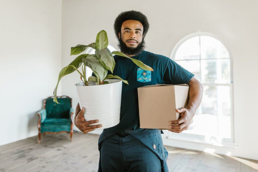 A cross-country mover holding a plant and a box