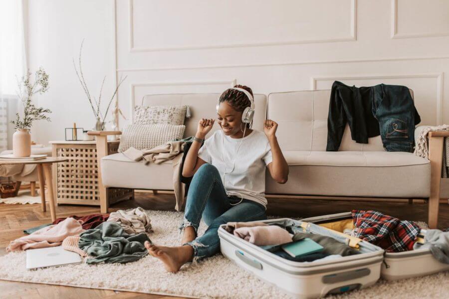 Girl dancing with headphones while packing