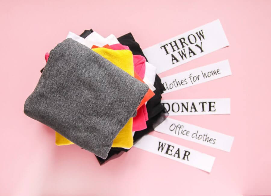 clothes with labels throw away, keep, wear, sell, give away, sorted for cross-country moving 