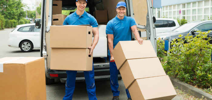 two cross-country movers standing in front of a long-distance moving truck