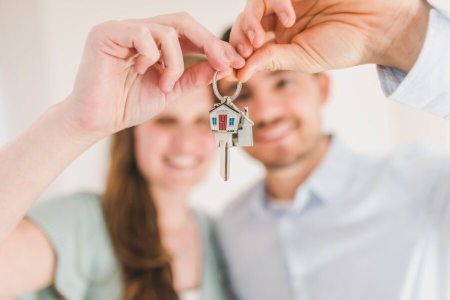 A couple holding their house key after cross-country moving 