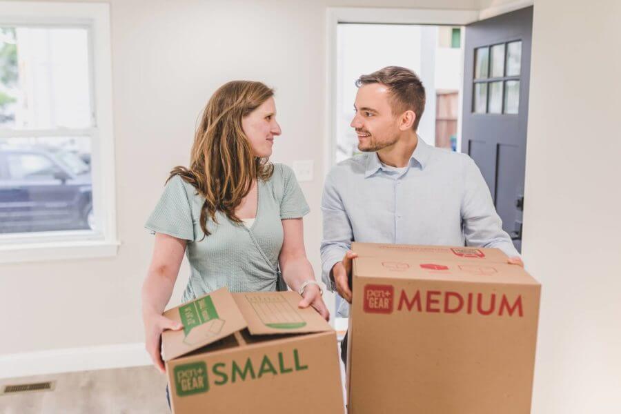 A couple carrying boxes after long-distance moving