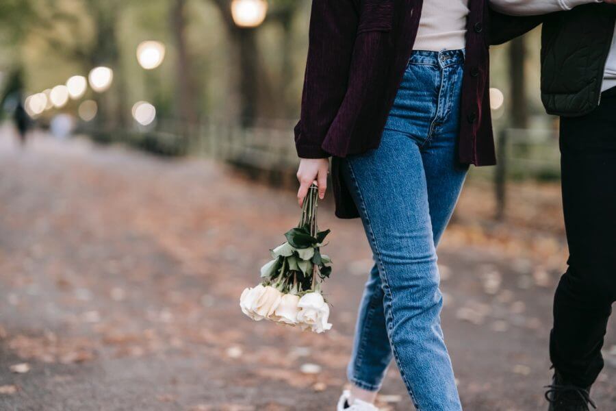 A couple walking with roses in hand