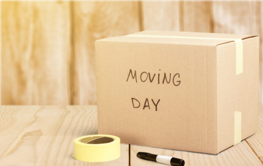 a box ready for moving cross-country with the words 'moving day' written on it