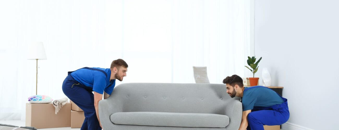 Long-distance movers lifting a sofa