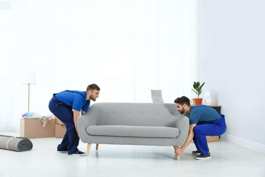 Long-distance movers lifting a sofa 
