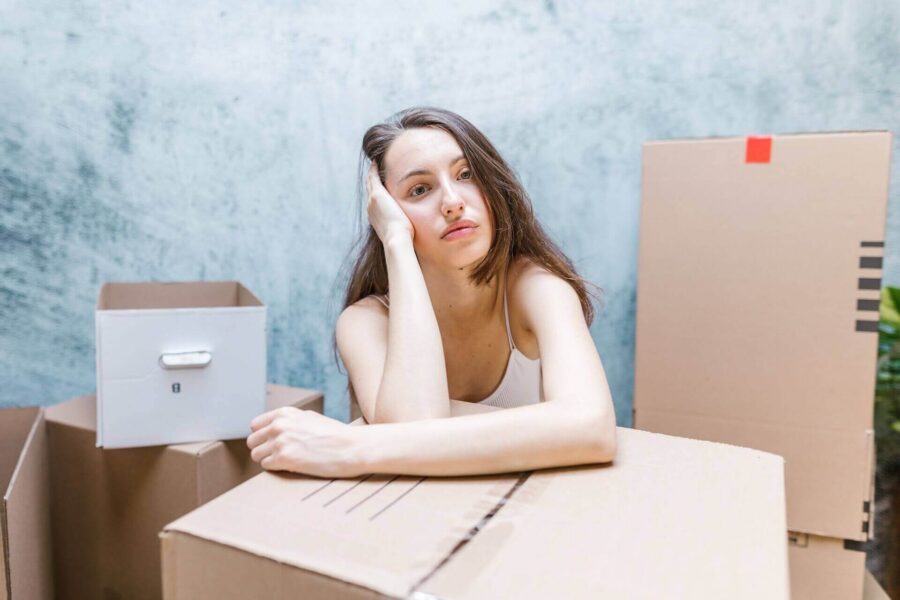 Anxious woman surrounded by boxes before moving cross country