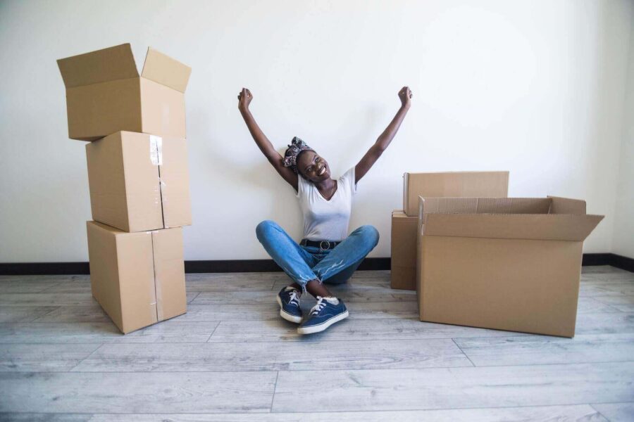 A happy woman surrounded by boxes after long-distance moving