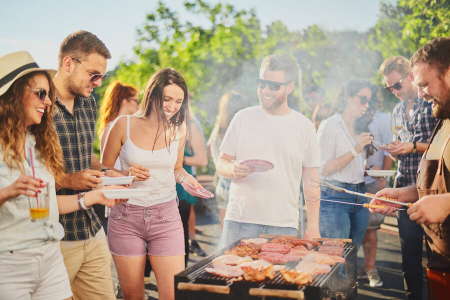 People next to the grill, smiling and talking