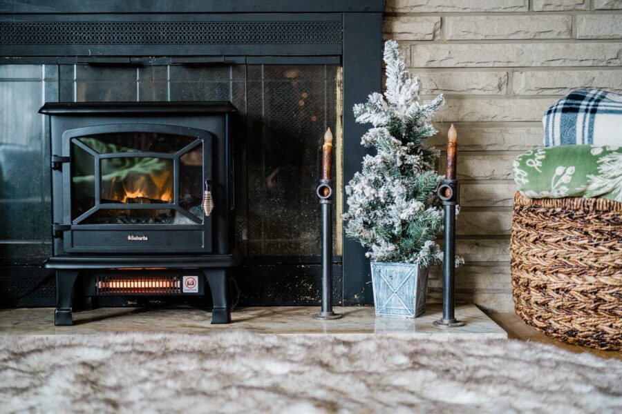 A cast iron fireplace beside a Christmas tree