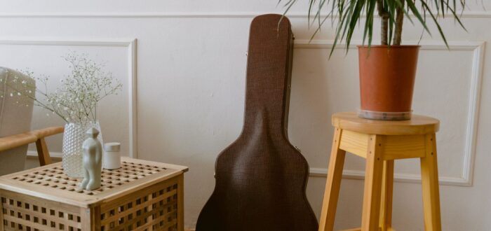 A guitar leaning on a wall in a case