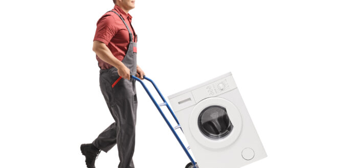 A mover moving a washing machine on a dolly