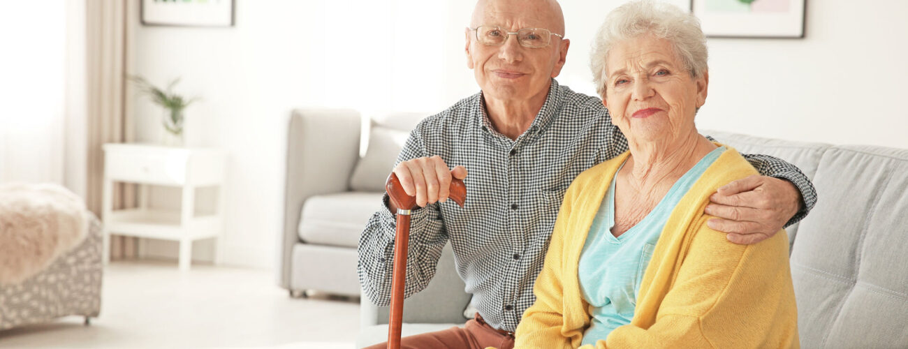 An elderly couple sitting on a sofa