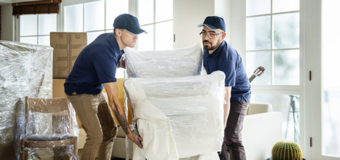 Movers wrapping an armchair