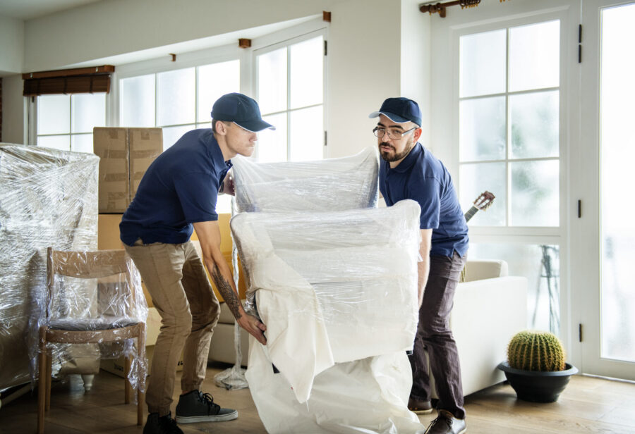 Movers wrapping an armchair 