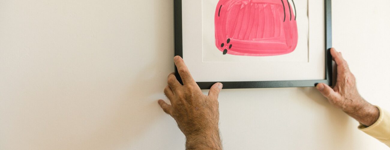 A man taking artwork off the wall