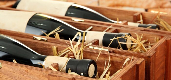 Bottles of old red wine in gift wooden box, on stone background