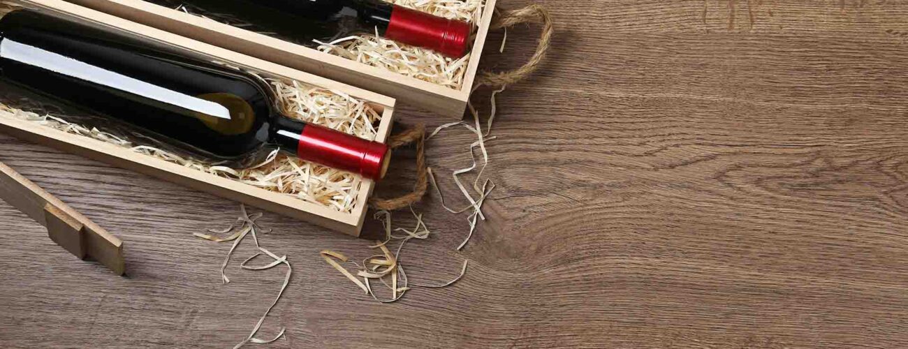 Wooden crates with expensive wine on table, flat lay. Space for text