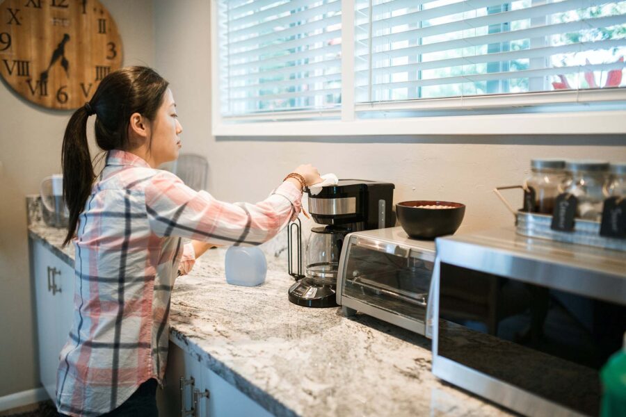 Woman cleaning a coffee maker