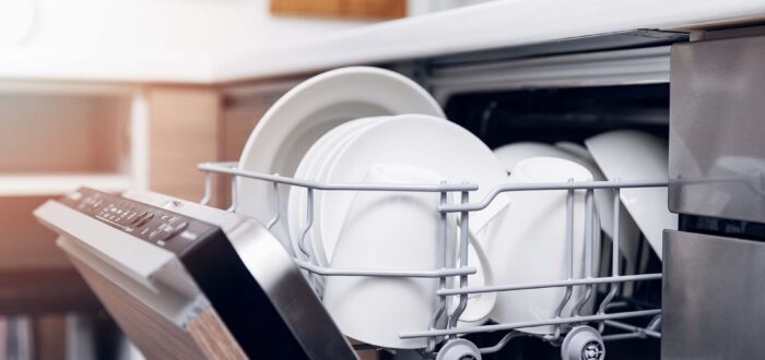 open dishwasher with clean dishes at home kitchen