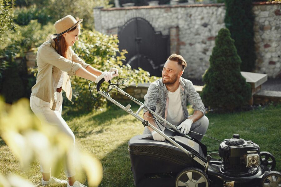A woman and man using a lawn mower