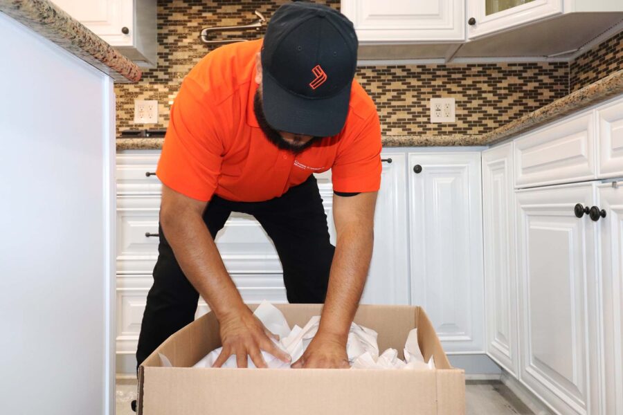 One of the cross-country movers packing a box