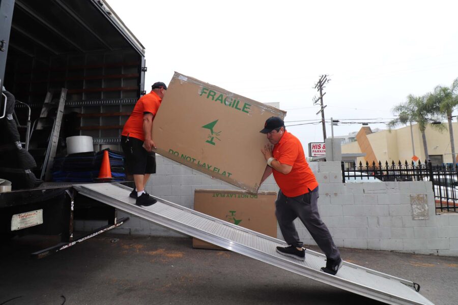 Cross-country movers loading the truck with a fragile box