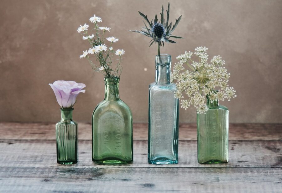 Four glass bottles filled with flowers