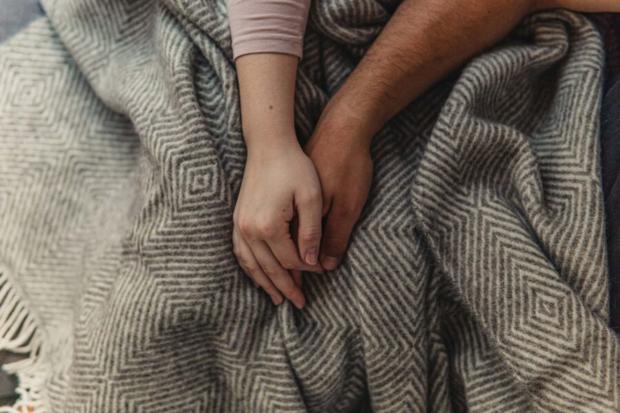 People holding hands over a blanket