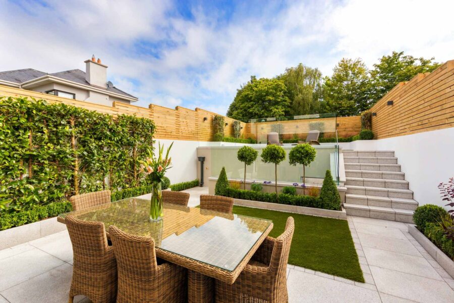 A patio with a table and chairs surrounded by a wall