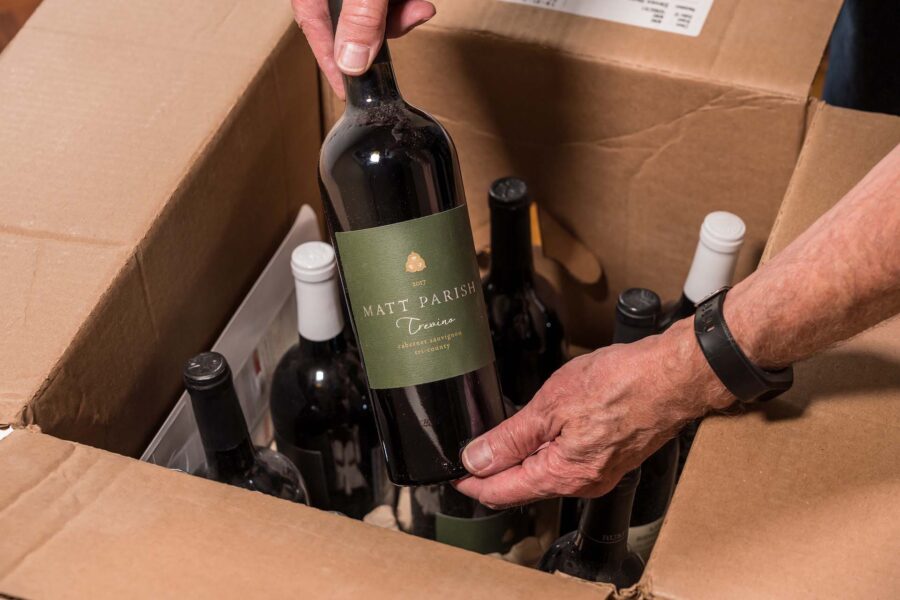 A man unpacking wine bottles after moving cross-country